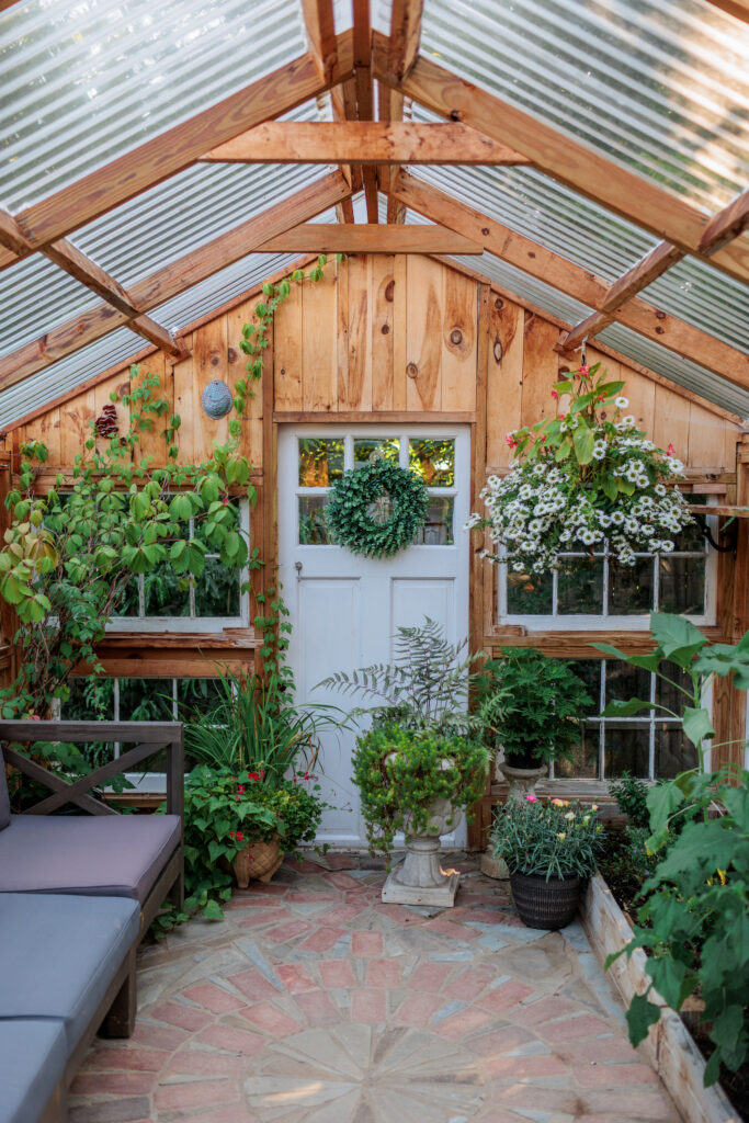  Interior view of a greenhouse with lush greenery and wooden walls, used for garden greenhouse boudoir photography in West Chester, PA.